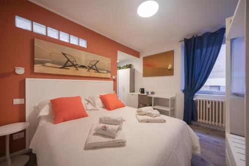 a bedroom with a large white bed with orange pillows at Casa Corallina Parma in Parma