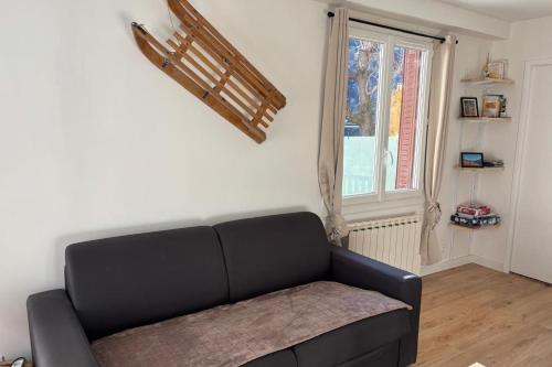 a black couch in a living room with a window at Mountain getaway in Saint-Chaffrey in Saint-Chaffrey