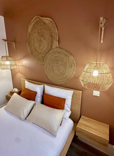 a bedroom with a bed and two hanging baskets at Studio 2 des Remparts à 5mins de Charleville-Mézières in Warcq