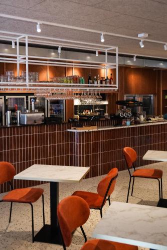 a restaurant with tables and chairs and a kitchen at BX Downtown - Brussels in Brussels