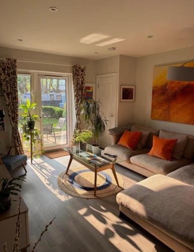 a living room with a couch and a table at Stylish Art Apartment with Canal in Uxbridge