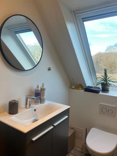 a bathroom with a sink and a mirror at Stay by pramskoven in Køge