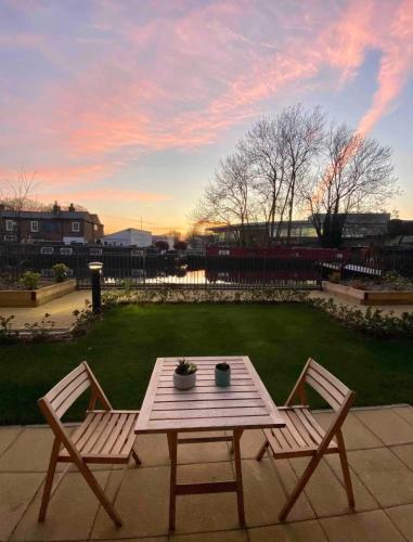 a picnic table and two chairs on a patio at Stylish Art Apartment with Canal in Uxbridge