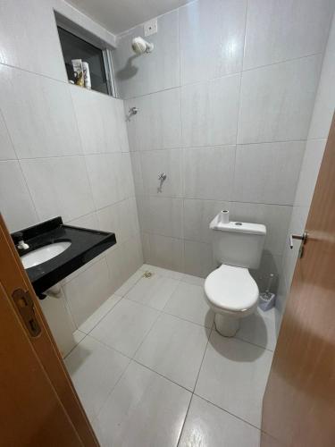 a white bathroom with a toilet and a sink at Przibilwiez Hause in João Pessoa