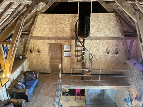 an attic room with a staircase and a couch at Auberge des Riders in Loze