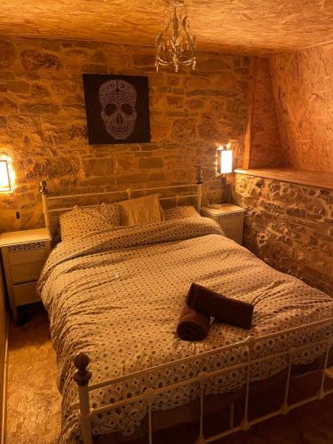 a bedroom with a bed with a skull picture on the wall at Auberge des Riders in Loze