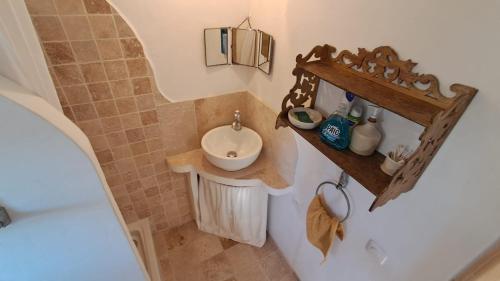 a small bathroom with a sink and a mirror at Chambre de la roche trouee GR49 in Trigance