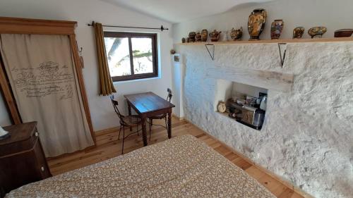 a bedroom with a bed and a stone fireplace at Chambre de la roche trouee GR49 in Trigance