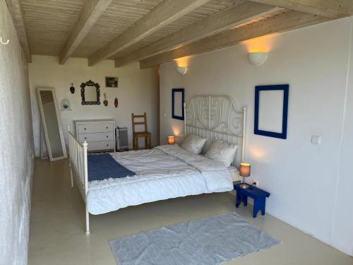a bedroom with a white bed and a blue rug at Aljezur Houses 3 bedrooms 2 bathrooms with Condo Pool in Aljezur