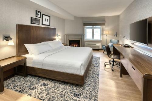 a hotel room with a bed and a desk and a television at Four Points by Sheraton Barrie in Barrie