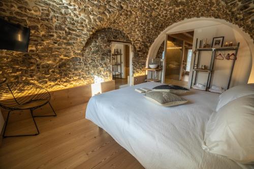 a bedroom with a large bed in a stone wall at Bazzario B&B in Lavarone