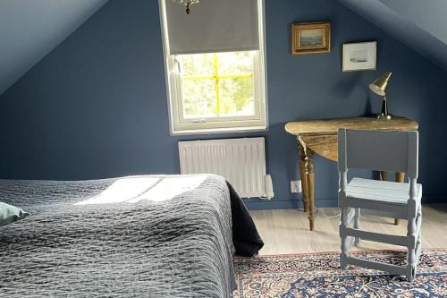 a bedroom with a bed and a desk and a chair at Villa Vitviken Sleeps 4 with Pool in Slite