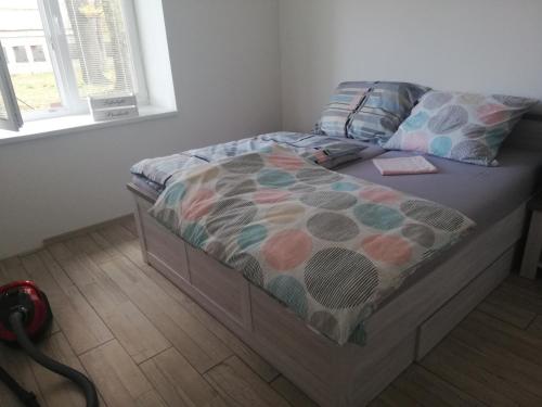 a bed with a comforter and pillows on it at Iglovia apartman in Spišská Nová Ves