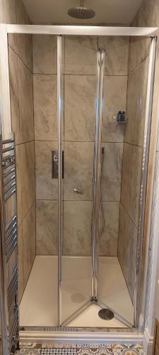 a shower with a glass door in a bathroom at The Snug in Haddenham