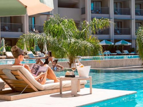 a group of people sitting in the swimming pool at a hotel at Hyde Bodrum - Ultra All Inclusive, Adult Only in Torba
