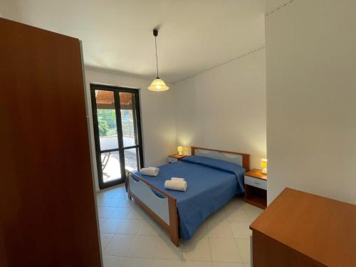 a bedroom with a blue bed and a window at Sweet Summer House in Campofelice di Roccella