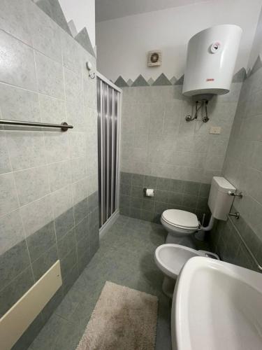 a bathroom with a toilet and a sink and a shower at Sweet Summer House in Campofelice di Roccella