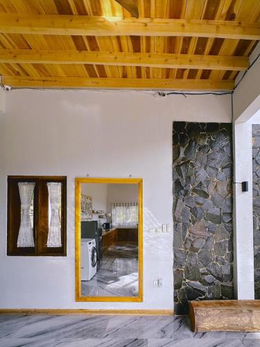 a room with a mirror and a stone wall at Wa'a House Batukaras in Batukaras