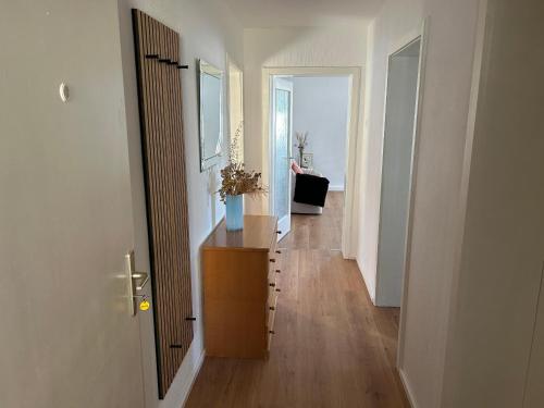 a hallway with a wooden dresser in a white room at Ferienwohnung Bärbel in Freyung