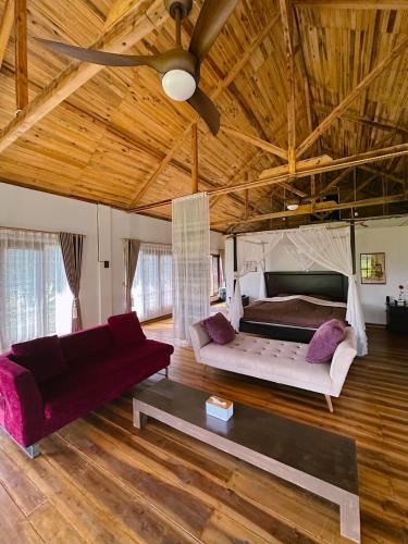 a living room with a bed and a couch at Wa'a House Batukaras in Batukaras