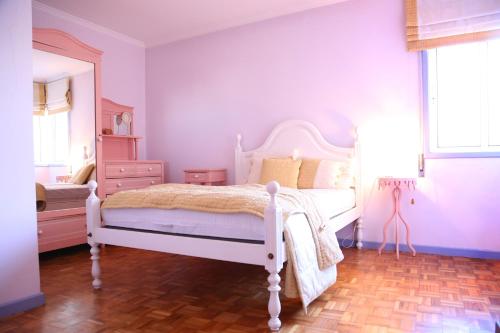Schlafzimmer mit einem weißen Bett und einem Spiegel in der Unterkunft Em Cima Da Areia in Póvoa de Varzim