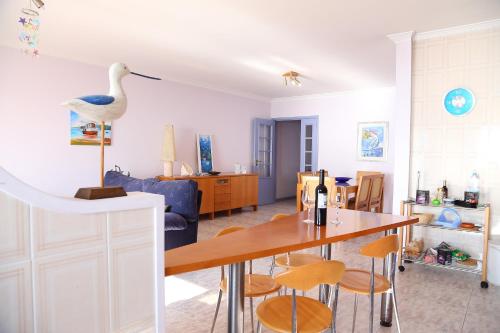 a living room with a table and a bird on the wall at Em Cima Da Areia in Póvoa de Varzim