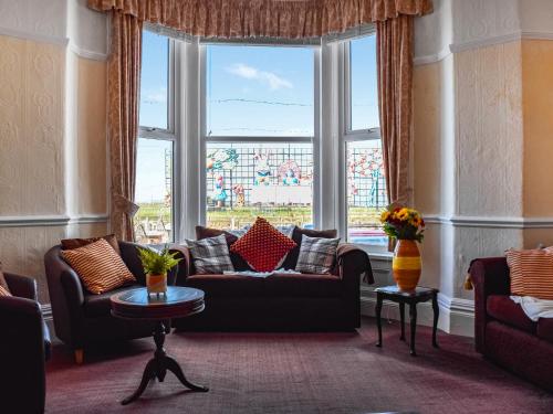 a living room with couches and a large window at Drumford in Blackpool