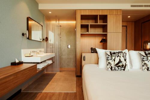 a bedroom with a bed and a bathroom with a sink at Van der Valk Hotel Amsterdam Zuidas-Rai in Amsterdam