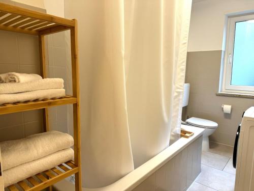 a bathroom with a shower curtain and a toilet at Charmant, Zentrumsnah, Natur in Augsburg