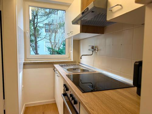 a small kitchen with a sink and a window at Charmant, Zentrumsnah, Natur in Augsburg