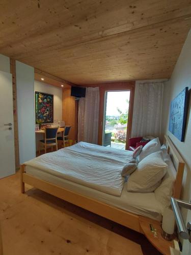ein großes Bett in einem Zimmer mit Fenster in der Unterkunft B&B Sunnesite Pratteln in Pratteln