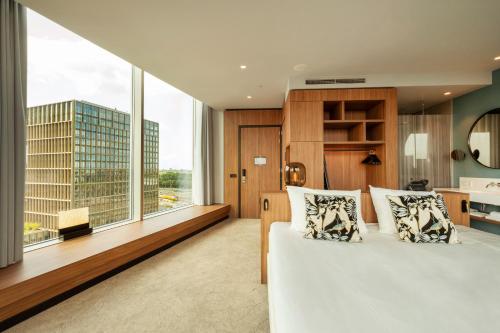a bedroom with a bed and a large window at Van der Valk Hotel Amsterdam Zuidas-Rai in Amsterdam