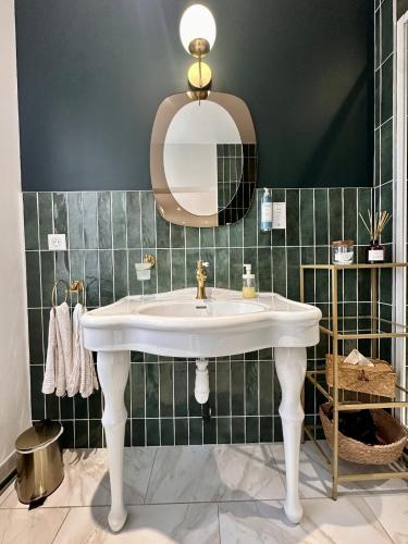 a bathroom with a white sink and a mirror at Studio 1 des Remparts à 5 mins de Charleville-Mézières in Warcq