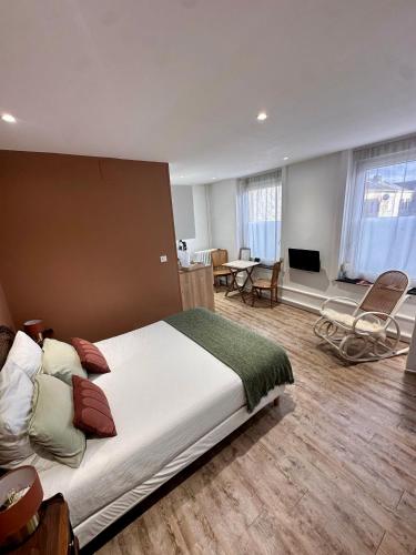 a bedroom with a large bed and a living room at Studio 1 des Remparts à 5 mins de Charleville-Mézières in Warcq