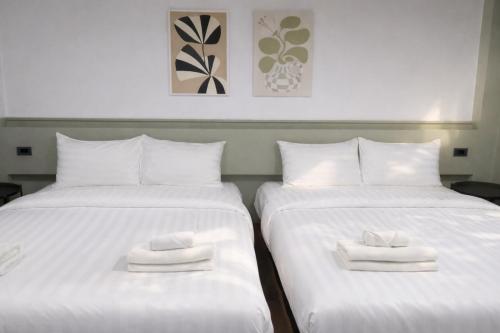 two beds with white towels on top of them at Quicky Stay Airport in Min Buri