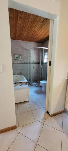 a bathroom with a tub and a sink and a toilet at Clarents Cottage in Somerset West