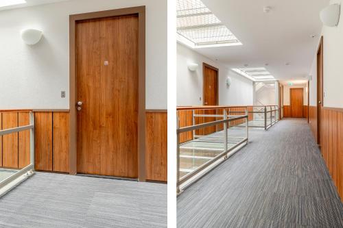an empty corridor in an office building with a wooden door at BizStay Harbour III Scheveningen Apartments in Scheveningen