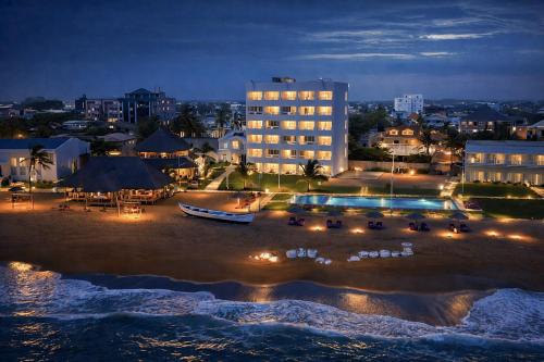 a view of a hotel and the beach at night at Hotel Petit Brussel in Lomé
