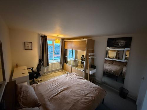 a bedroom with a bed and a desk and a mirror at Birch House in London