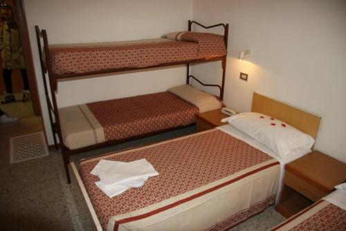 a small room with two bunk beds in it at Hotel Orchidea Rimini in Rimini