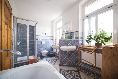 a bathroom with a tub and a sink and a toilet at Körnermühle in Dippoldiswalde