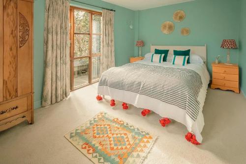 a bedroom with a bed and a window at Tredethick Farm Cottages in Lostwithiel