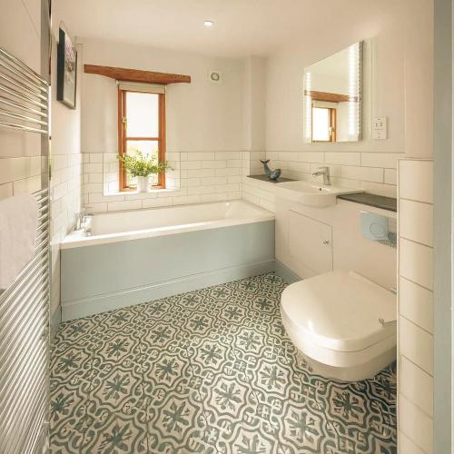 a bathroom with a tub and a toilet and a sink at Tredethick Farm Cottages in Lostwithiel