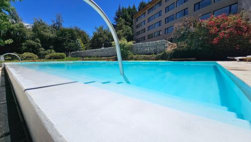 an empty swimming pool with a curved pool coping at Pioneros Suites by Grupo Tierra Gaucha in San Carlos de Bariloche