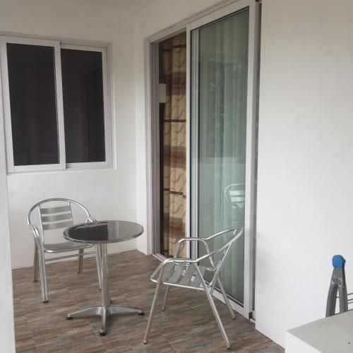 a patio with a table and chairs and a glass door at Villa Capri first floor in Quatre Bornes