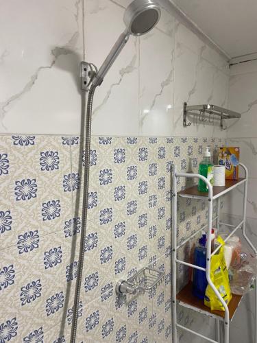 a shower in a bathroom with blue and white tiles at Nid douillet kribi in Kribi
