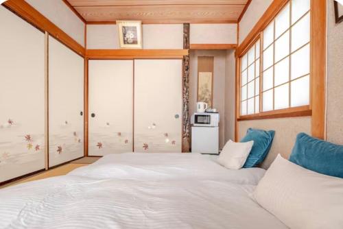 a bedroom with a large white bed in a room at TOMO HOUSE in Taketoyo