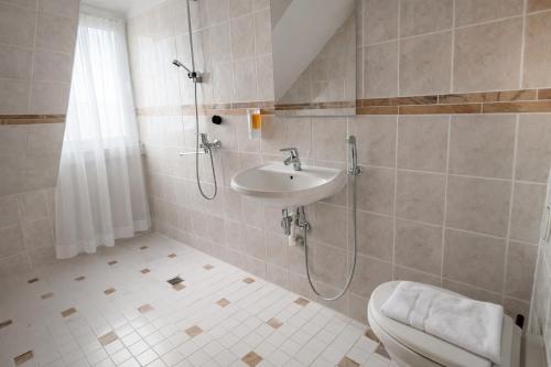 a bathroom with a shower and a sink and a toilet at Sonne Hotel in Herne