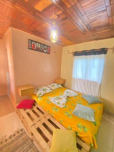 a bedroom with a large yellow bed with a window at Nid douillet kribi in Kribi