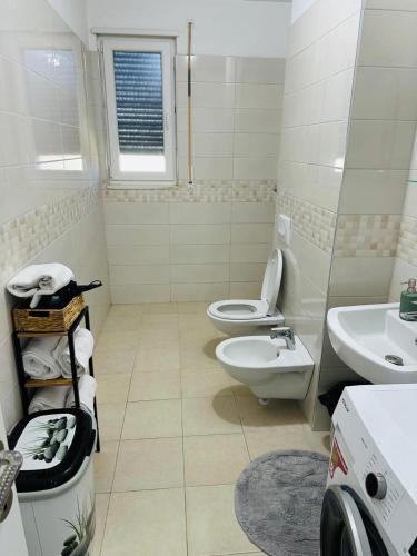 a white bathroom with two toilets and a sink at Valamar Deluxe Beachfront Villa in Draç